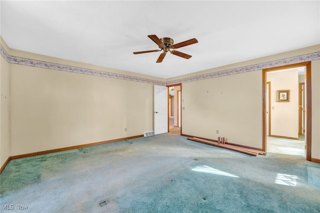 carpeted empty room featuring visible vents, baseboards, and a ceiling fan