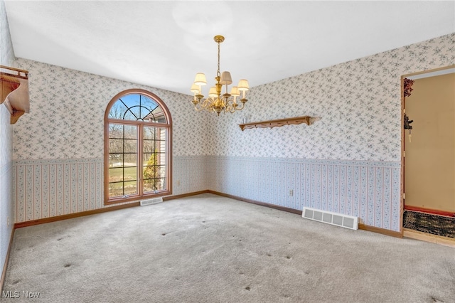 empty room with a chandelier, visible vents, carpet flooring, and wallpapered walls