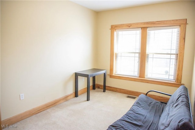 living area with plenty of natural light, baseboards, visible vents, and carpet floors