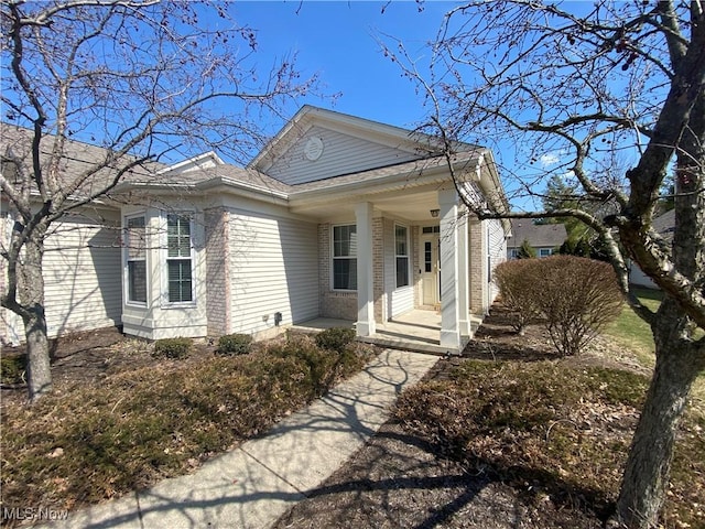 view of front of home with brick siding and covered porch