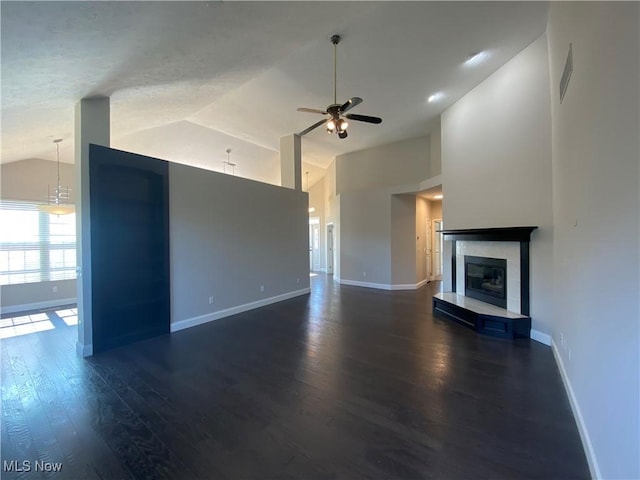 unfurnished living room with a glass covered fireplace, baseboards, dark wood-type flooring, and ceiling fan