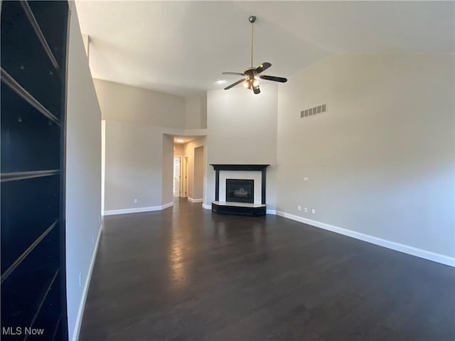 unfurnished living room featuring a ceiling fan, visible vents, baseboards, high vaulted ceiling, and a glass covered fireplace