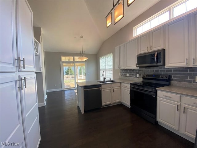 kitchen featuring dishwashing machine, black / electric stove, a peninsula, a sink, and white cabinetry