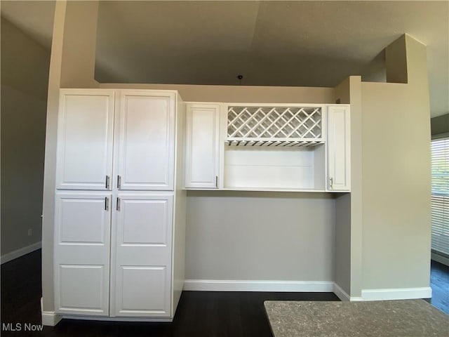 kitchen with white cabinetry, baseboards, and dark wood-style flooring