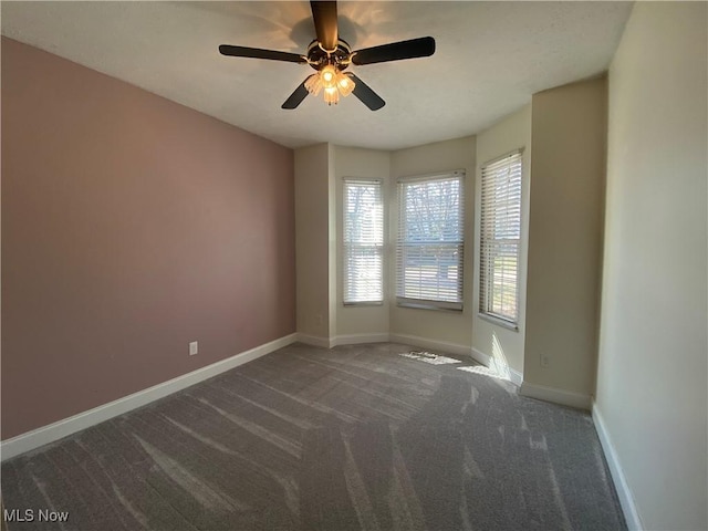 carpeted empty room featuring baseboards and ceiling fan