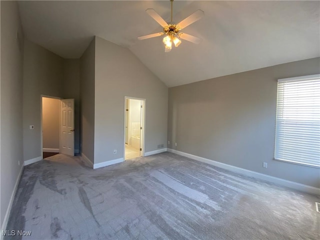 unfurnished bedroom with carpet, baseboards, high vaulted ceiling, ceiling fan, and ensuite bathroom