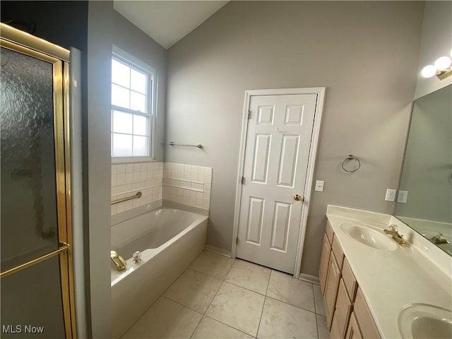 bathroom with double vanity, a sink, vaulted ceiling, a shower stall, and a garden tub