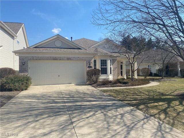 single story home featuring a front yard, an attached garage, brick siding, and driveway