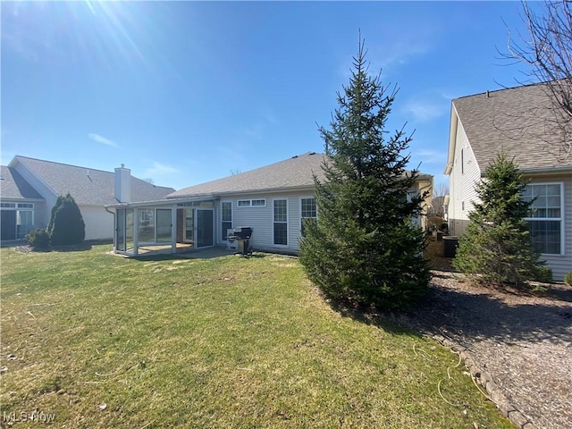 back of property featuring a yard and a sunroom