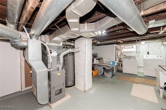 below grade area featuring heating unit and separate washer and dryer