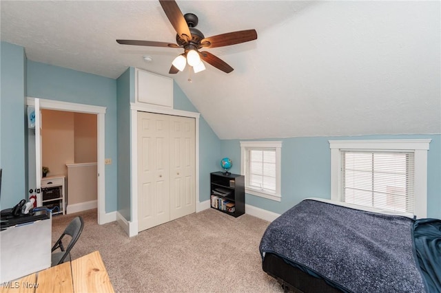 bedroom featuring baseboards, ceiling fan, vaulted ceiling, a closet, and light carpet