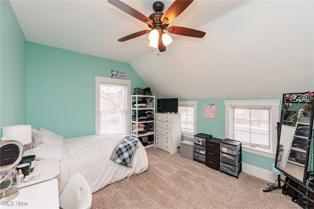 bedroom featuring carpet flooring, vaulted ceiling, multiple windows, and a ceiling fan