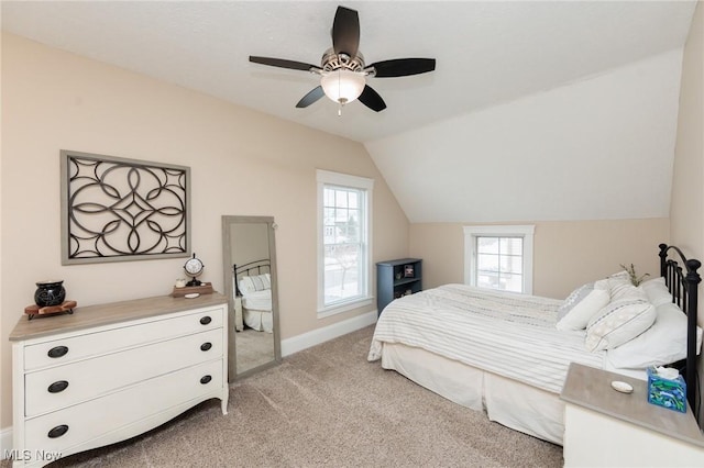 bedroom featuring a ceiling fan, vaulted ceiling, light colored carpet, and baseboards