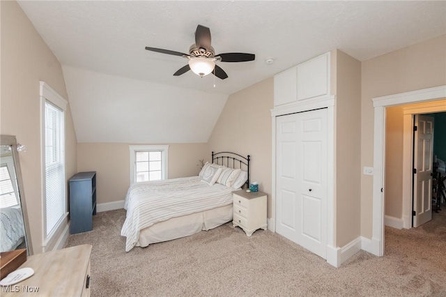 bedroom with baseboards, light colored carpet, lofted ceiling, and a ceiling fan