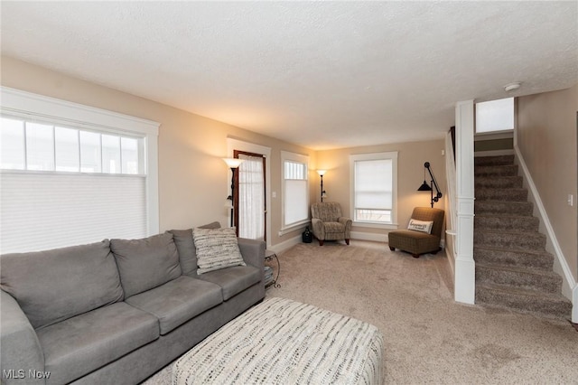 living room with baseboards, carpet, stairs, and a textured ceiling