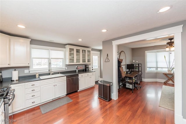 kitchen featuring dark countertops, white cabinetry, stainless steel appliances, and a sink