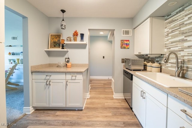 kitchen featuring dishwasher, visible vents, backsplash, and a sink