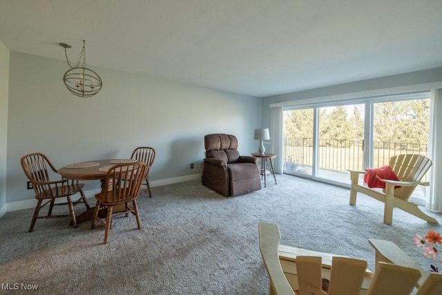 carpeted dining space featuring baseboards