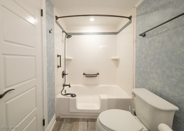 bathroom featuring toilet, wood finished floors, and shower / bathtub combination