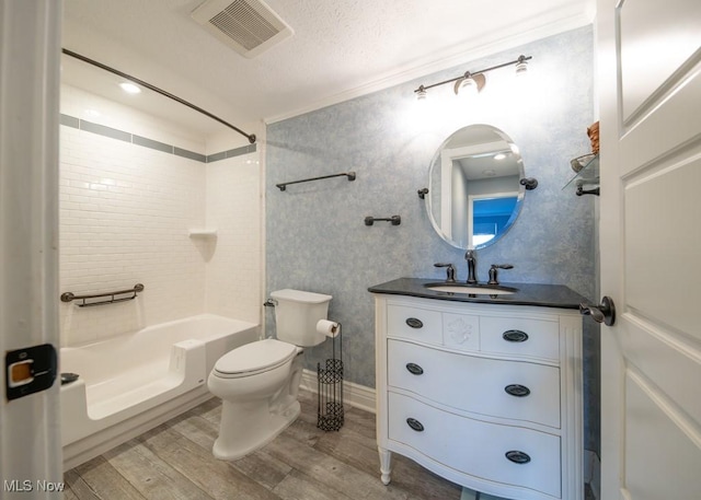 bathroom with vanity, wood finished floors, visible vents, shower / washtub combination, and toilet