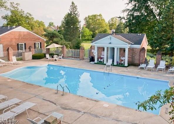 community pool featuring an exterior structure, fence, an outbuilding, and a patio area