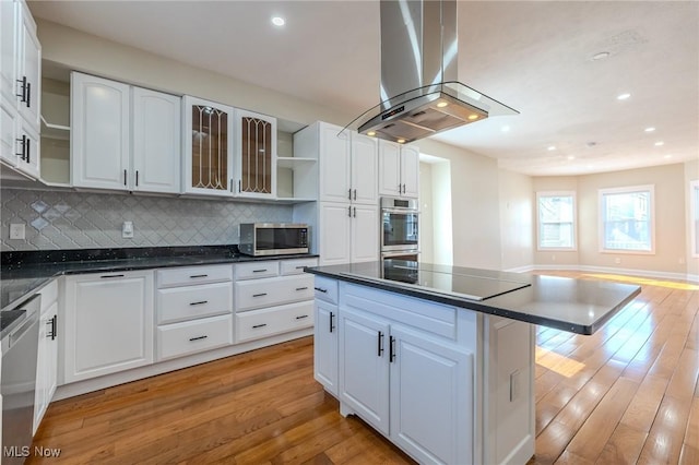 kitchen featuring dark countertops, light wood-style flooring, stainless steel appliances, and island range hood