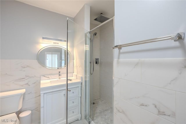 bathroom featuring vanity, toilet, tile walls, and a shower stall