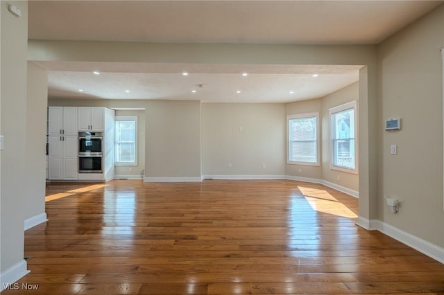 unfurnished living room featuring recessed lighting, baseboards, and hardwood / wood-style floors