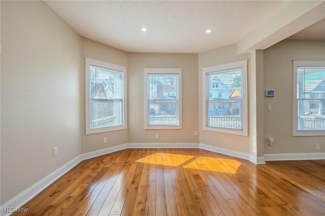 unfurnished room featuring recessed lighting, baseboards, and light wood-style flooring