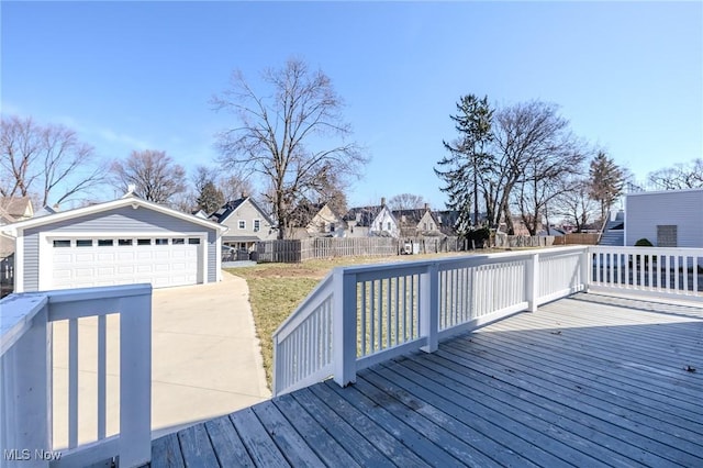 wooden deck with an outdoor structure, fence, a residential view, and a detached garage