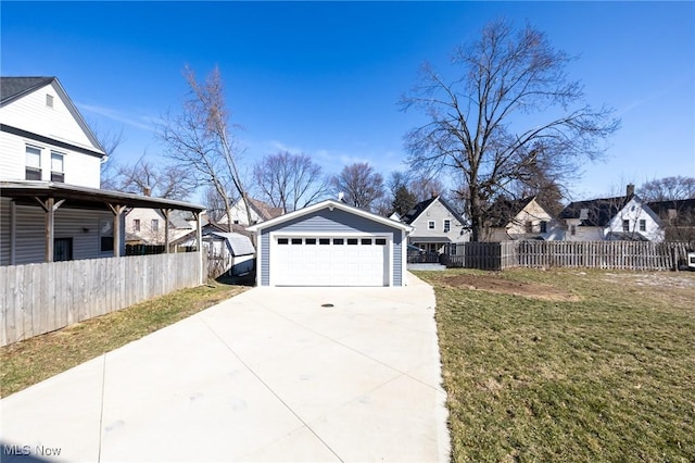 view of yard featuring an outbuilding, fence, a residential view, and a detached garage