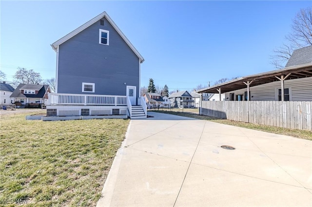 view of property exterior featuring fence, a lawn, and a residential view