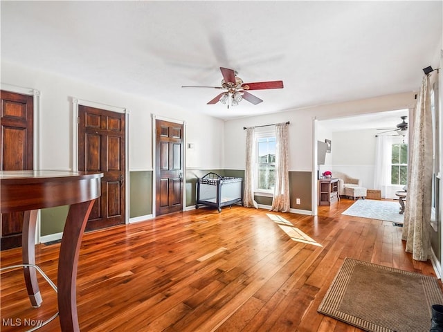 interior space with plenty of natural light, baseboards, ceiling fan, and hardwood / wood-style floors