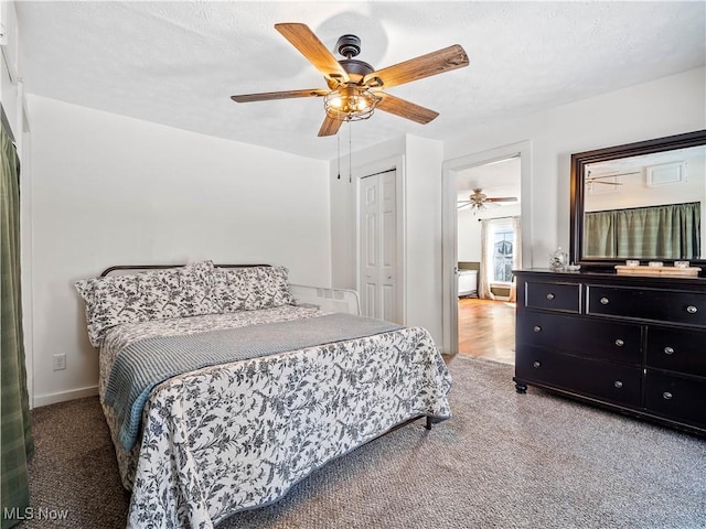 carpeted bedroom featuring a closet, a textured ceiling, and a ceiling fan