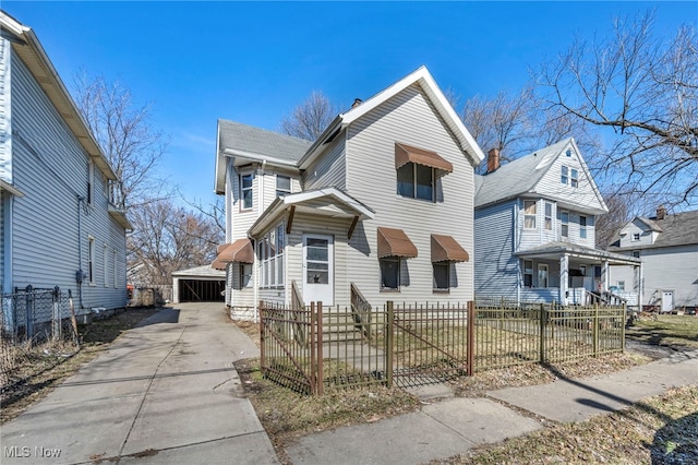 view of front of home with a fenced front yard, a detached garage, and an outdoor structure