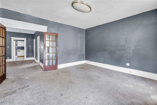 unfurnished room featuring french doors and baseboards