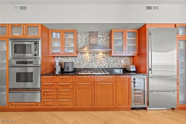 kitchen with a warming drawer, visible vents, stainless steel appliances, wine cooler, and wall chimney exhaust hood