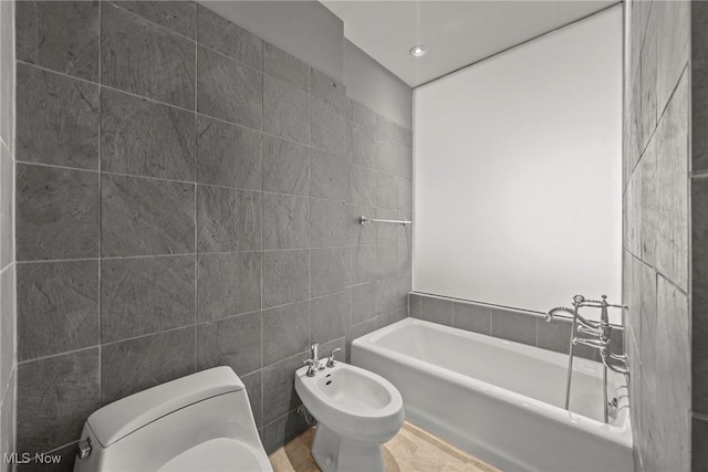 full bath featuring tile walls, toilet, a bathtub, and a bidet