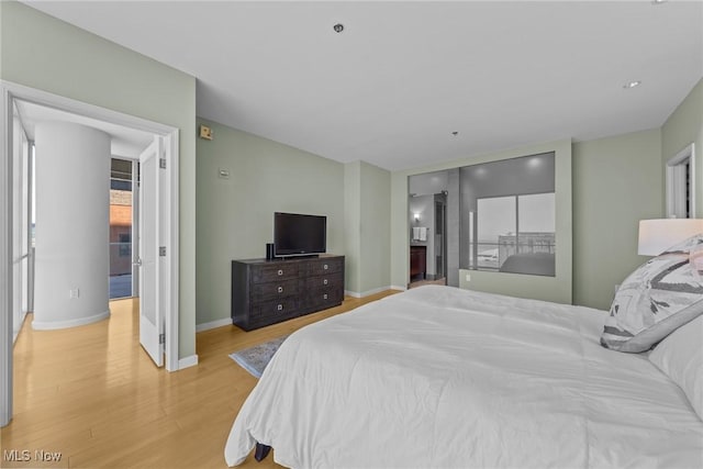 bedroom featuring baseboards and light wood finished floors