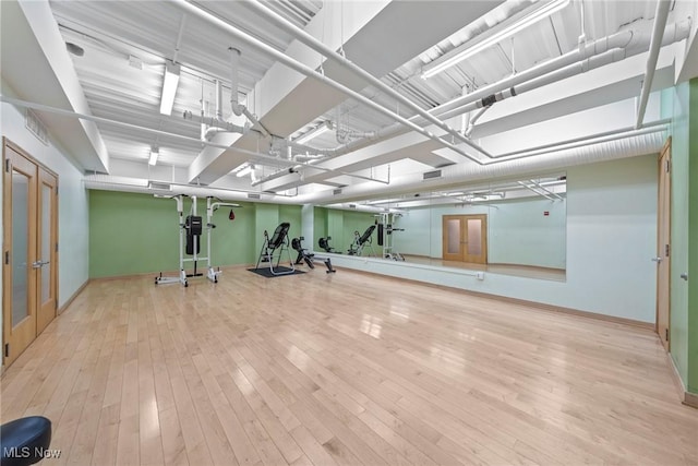 exercise area featuring french doors and wood-type flooring