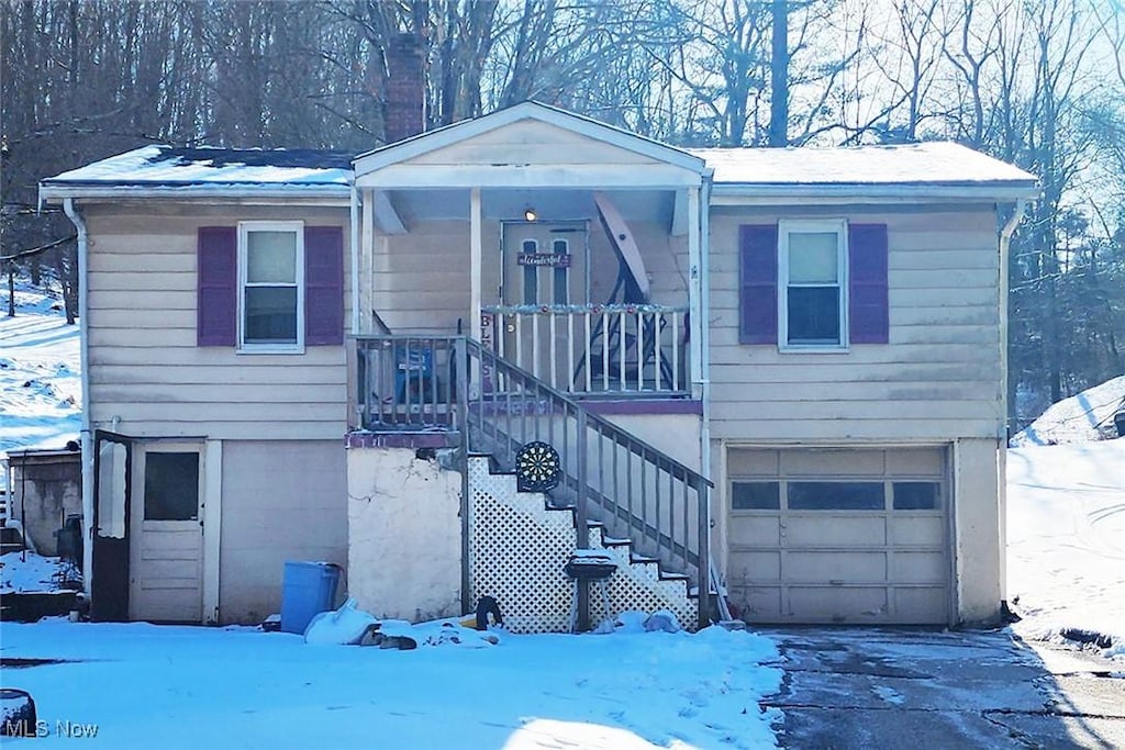 view of front of house with stairway, driveway, and a garage