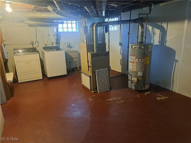 basement featuring water heater, heating unit, and washing machine and dryer