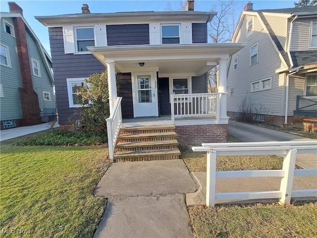 view of front of property featuring covered porch and a chimney