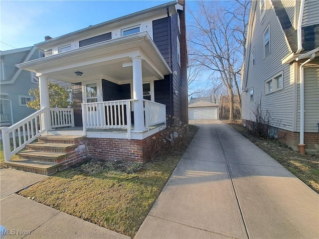 view of front facade featuring a porch, an outbuilding, and a detached garage