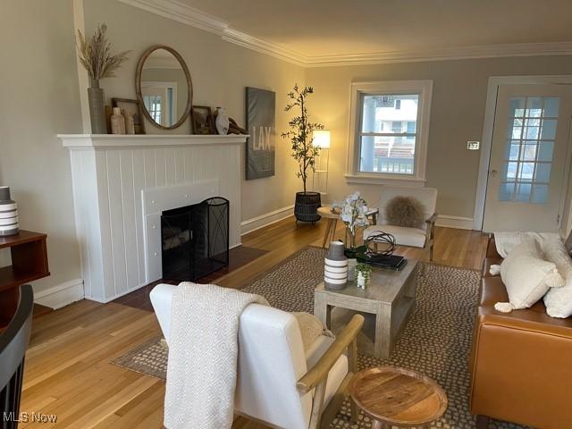 living room with plenty of natural light, wood finished floors, and crown molding