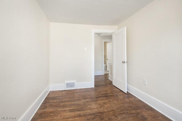 empty room with visible vents, baseboards, and wood finished floors