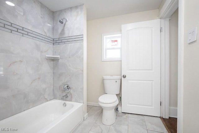 full bath featuring baseboards, toilet, and shower / washtub combination