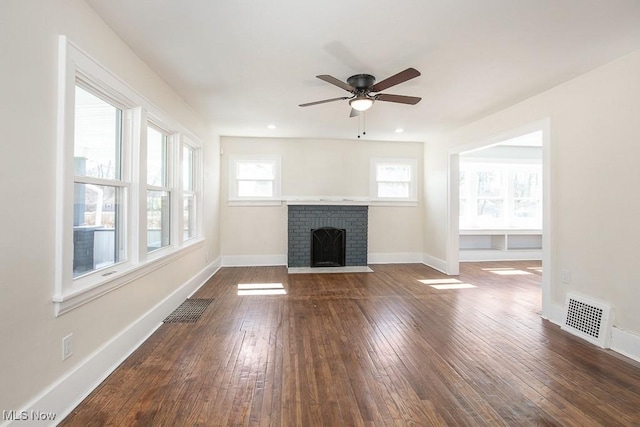 unfurnished living room featuring dark wood finished floors, visible vents, ceiling fan, and baseboards