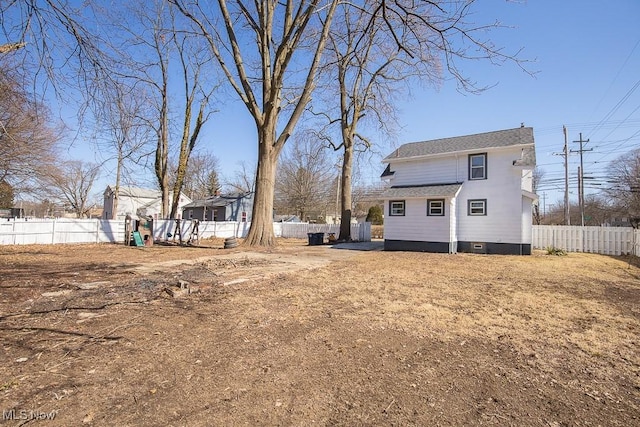 exterior space with a shingled roof, a fenced backyard, and a playground