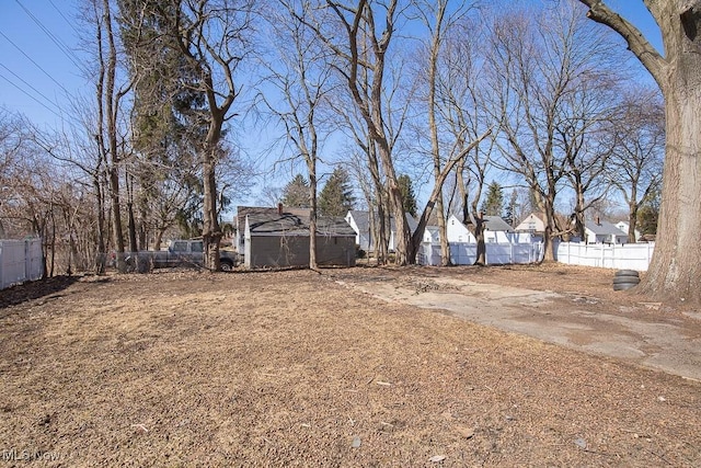 view of yard with a storage shed, an outdoor structure, and fence